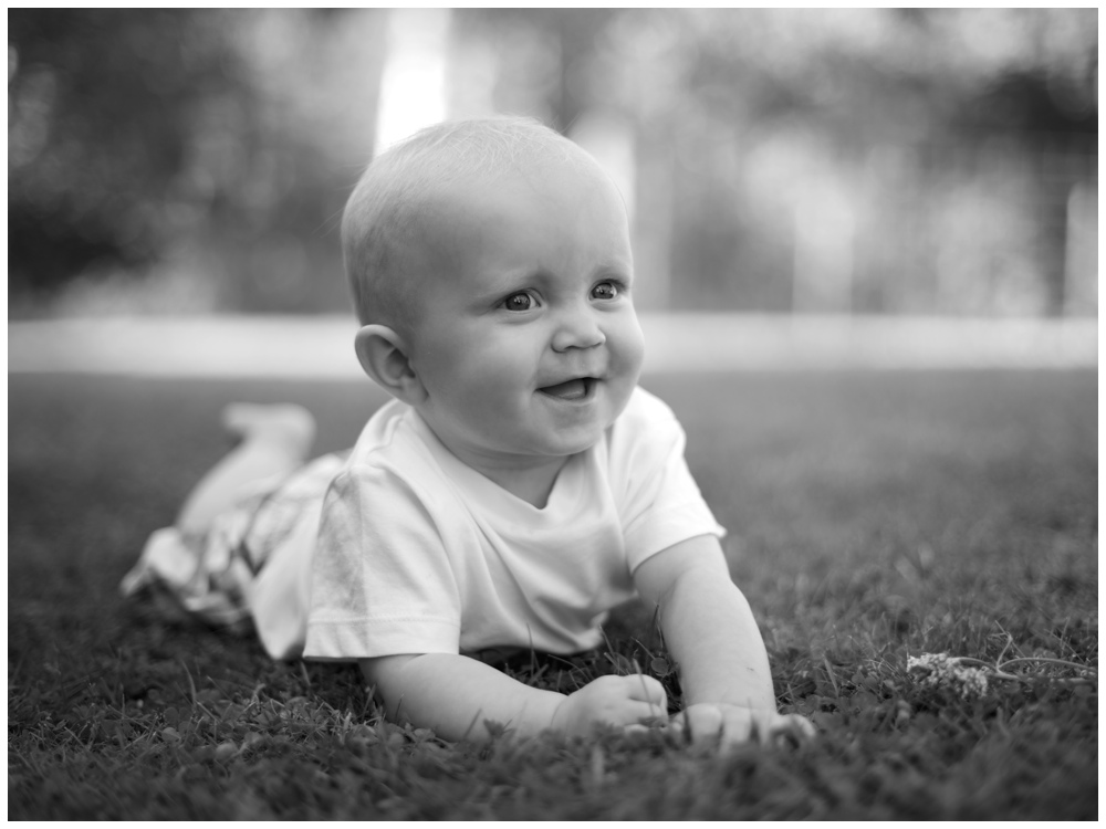 Barnfotografering utomhus med barnfotograf Erika Aminoff Glad pojke i gräset 